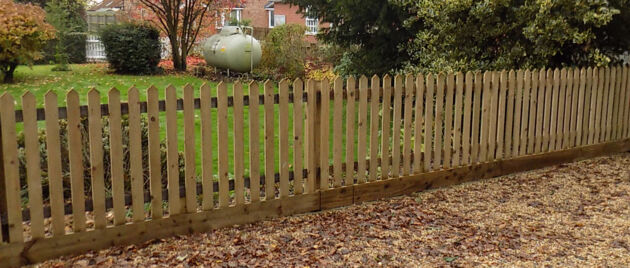 Palisade fencing with pointed tops and gravel boards