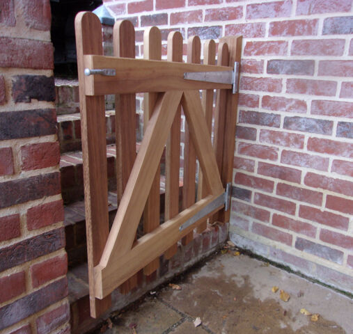 Palisade gate with round tops in untreated Iroko