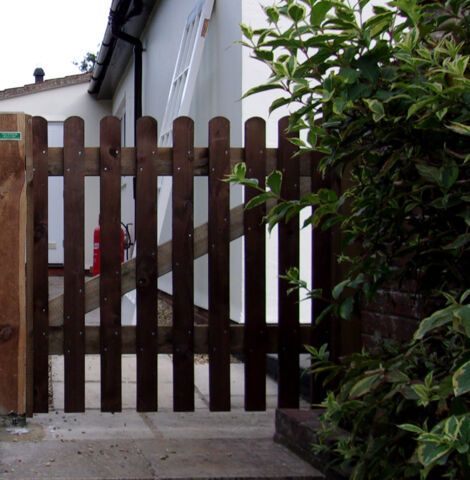 Palisade gate in planed timber with round top pales